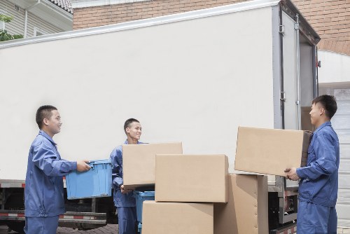 Packed boxes and furniture being loaded into a van